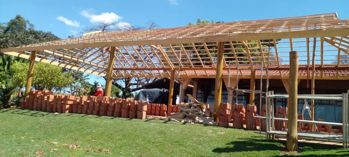 Estrutura de telhado em eucalipto tratado sendo montada sobre pilares roliços